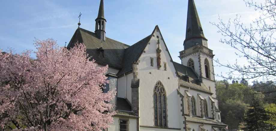 Kirche St. Laurentius mit blühendem Baum im Vordergrund