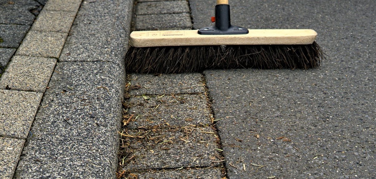 Straße mit Besen fegen