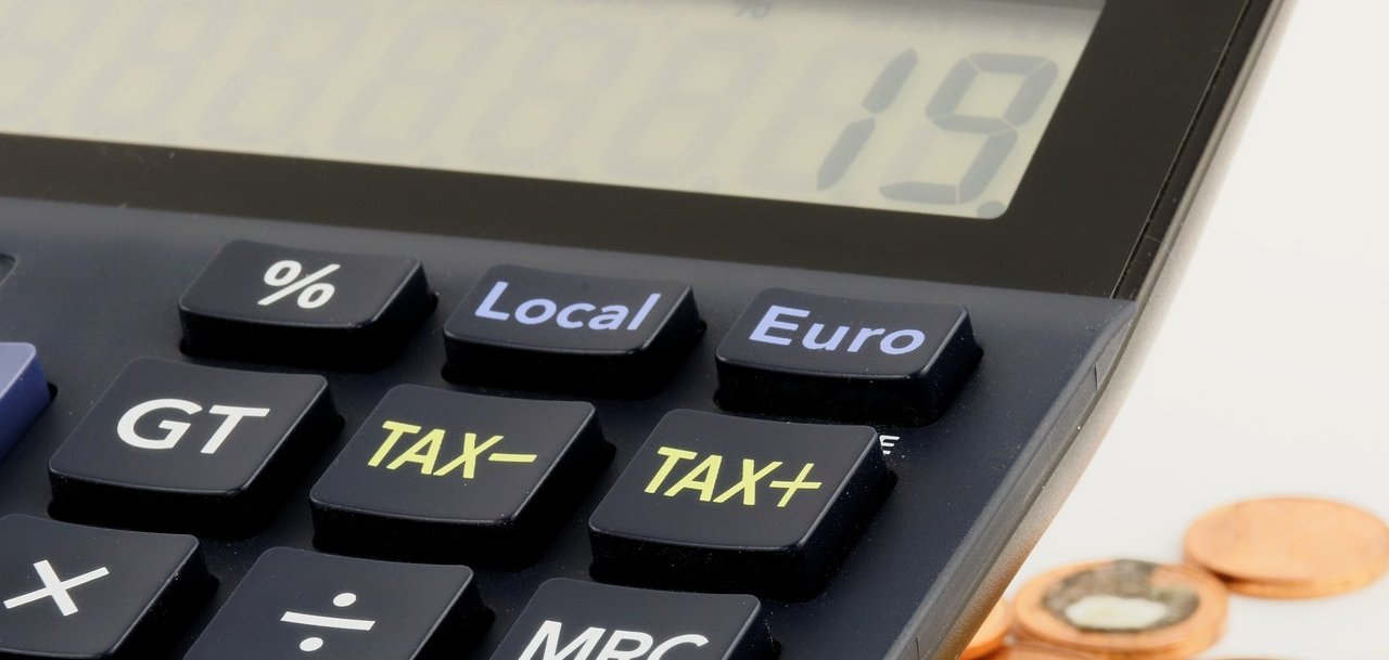 Taschenrechner neben Geldmünzen