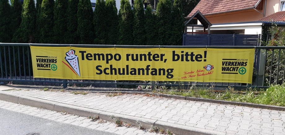 Gelber Banner mit der Aufschrift „Tempo runter, bitte! Schulanfang“ 